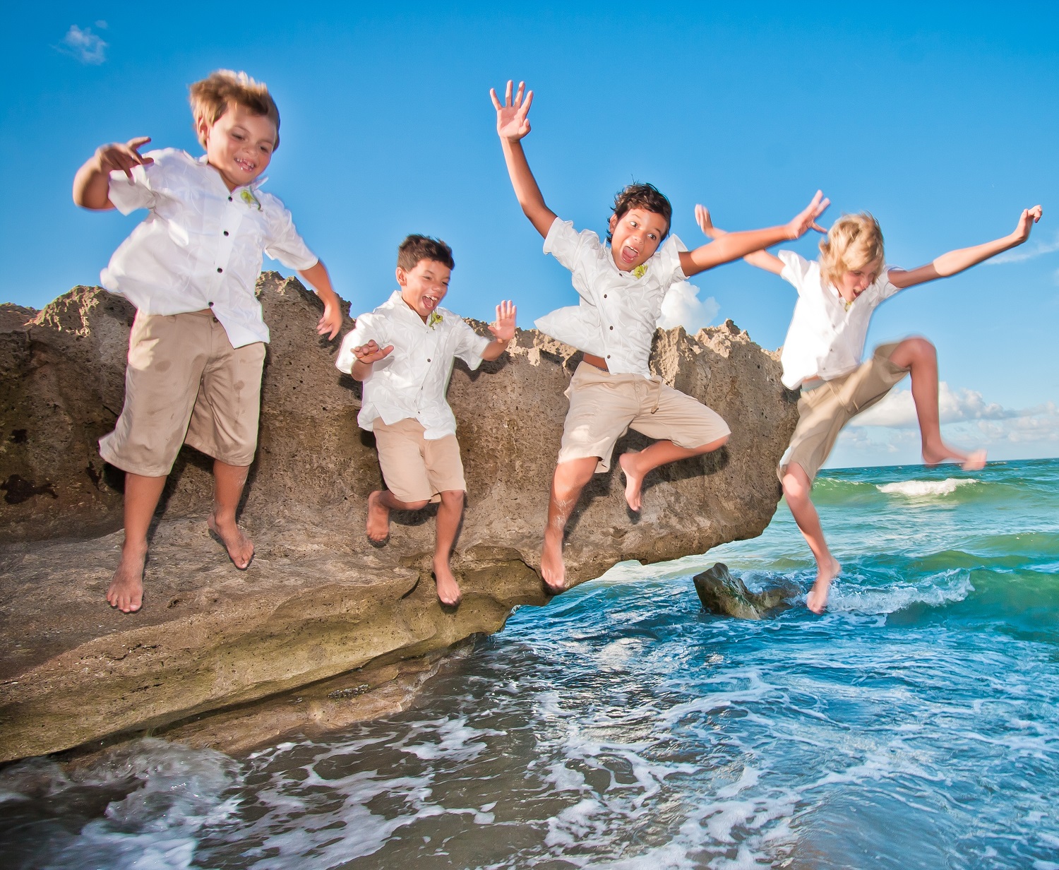 Tropaholic.com-Beach-Wedding-clothes-boys-jumping-off-rocks-into-the-water