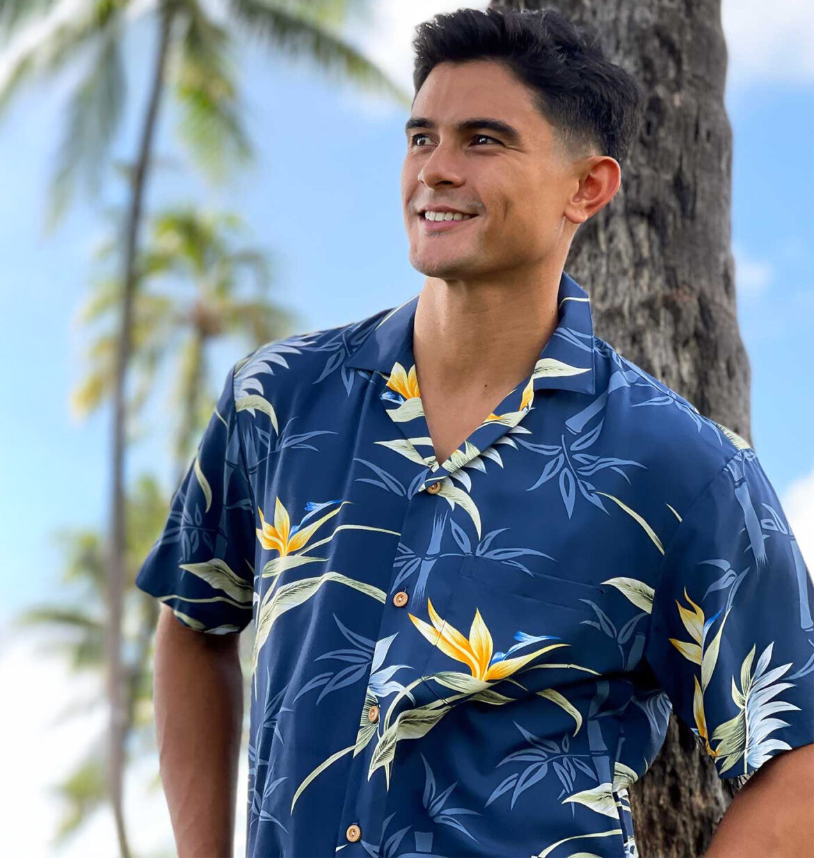 Mens-Hawaiian-Shirt-Paradise-Found-Bamboo-Paradise-Navy-Model-leaning-against-palm-tree-in-Hawaii-USA