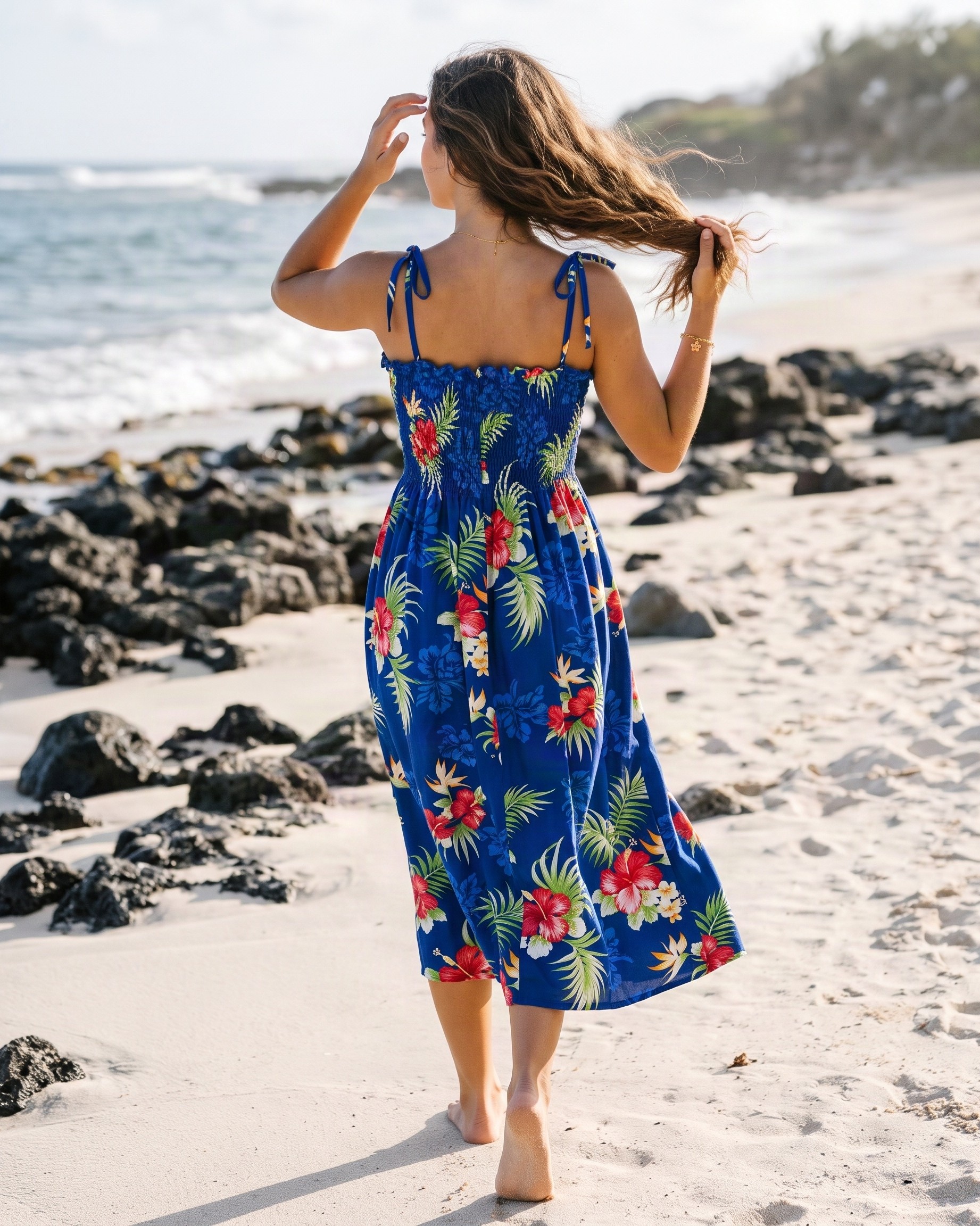 hawaiian-tube-top-sundress-hibiscus-fern-blue-model-walking-on-hawaiian-beach-with-volcanic-rock-back-view