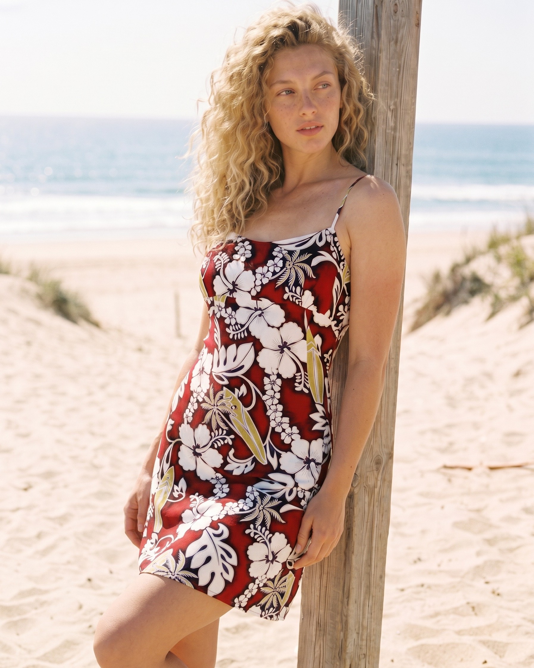 Short-Spaghetti-Strap-sundress-Hang-Loose-Red-Model-on-the-beach-leaning-on-a-wooden-post-close-up-shot